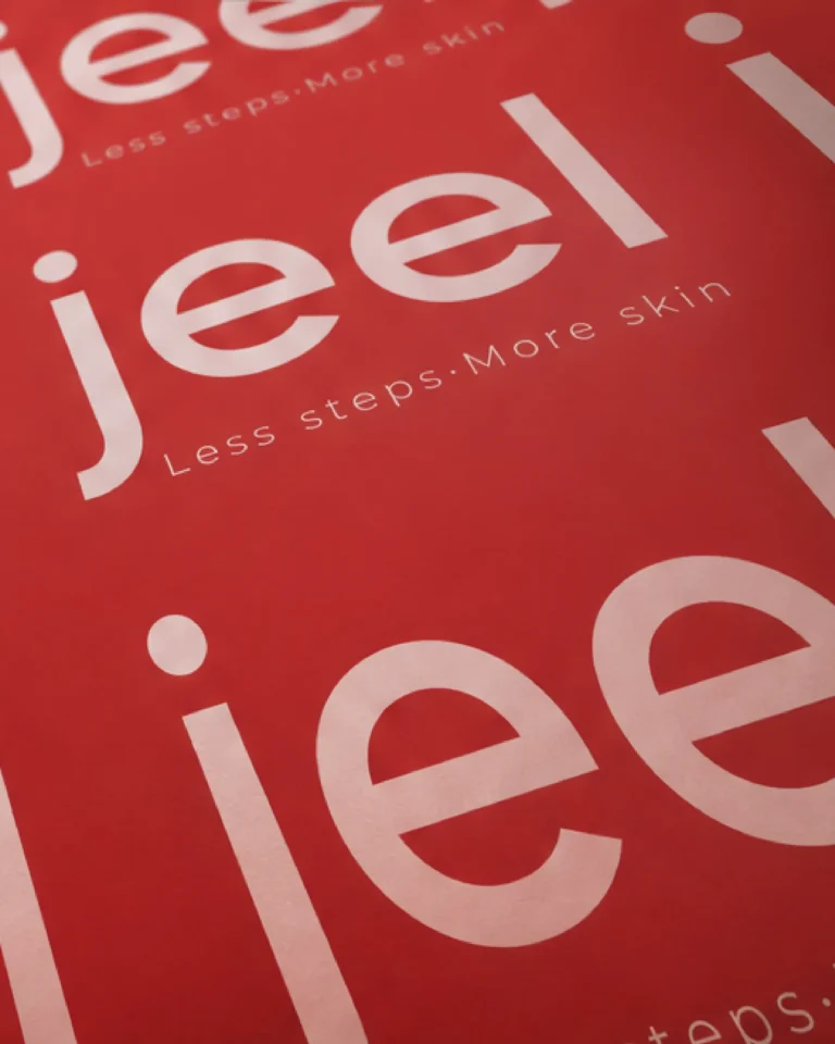 Papel con patrón del logotipo de Jeel y el claim Less steps. More skin en rojo